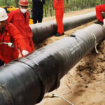 Heat shrink sleeve being installed over pipeline girth weld — field joint coating process