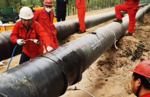 Heat shrink sleeve being installed over pipeline girth weld — field joint coating process