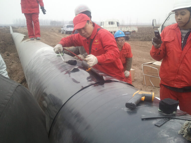 Heat shrinkable sleeve being installed over 3LPE coated steel pipe — field joint coating for pipeline corrosion protection
